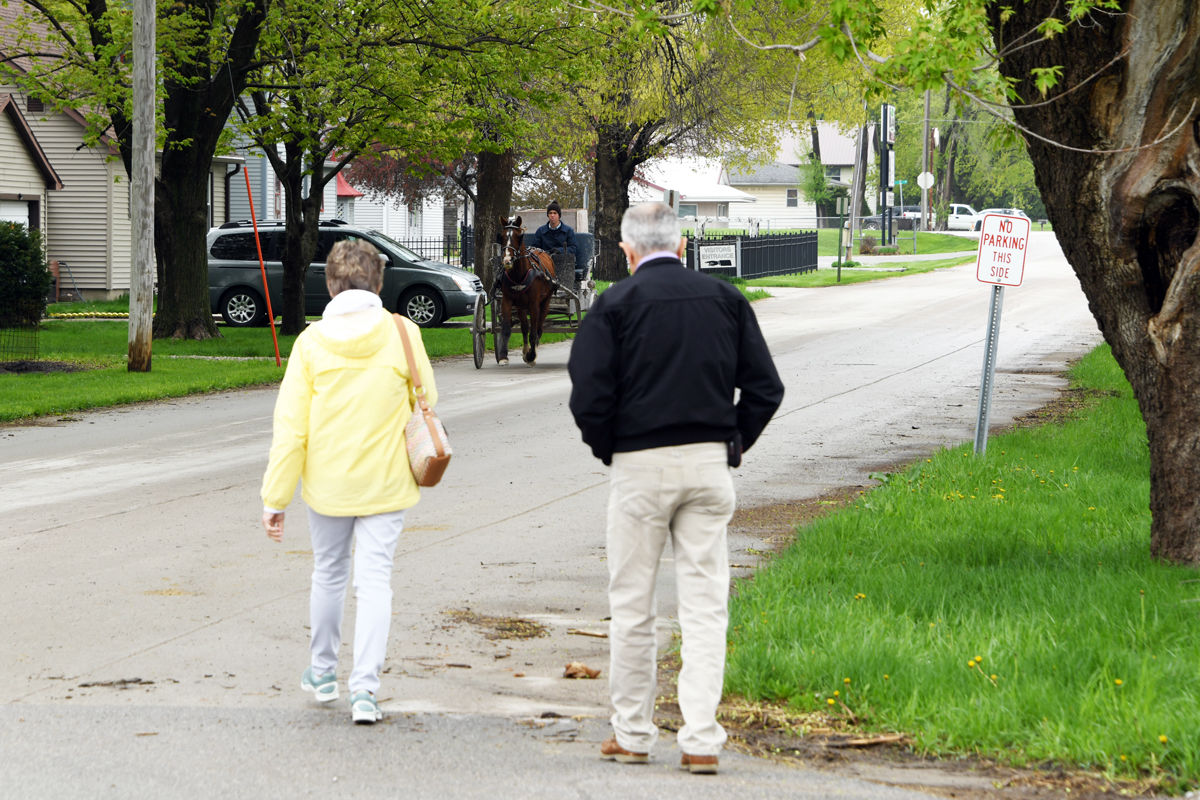 099 Sherry and Delmar Peters leave the Kalona Sales Barn as an Amish buggy approaches.JPG